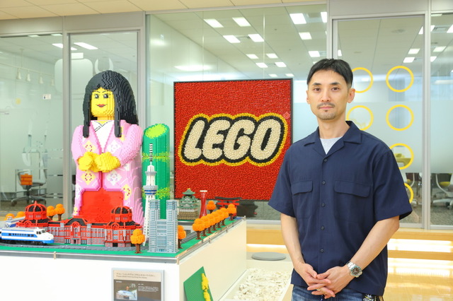 レゴジャパンシニアマーケティングマネジャーの橋本優一氏。エントランスには日本で唯一の「レゴ認定プロビルダー」三井淳平さんの作品が飾られていた