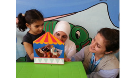ユニセフ教育専門官とともに、ユニセフのECDキットに含まれている指人形を使って遊ぶ、シリアの女の子（5歳） (c) UNICEF_UNI176330_Youngmeyer