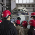 格納庫見学の案内は、パイロット、航空整備士、客室乗務員などの経験者が担当する。写真はJA8001「富士」を見学した班のようす