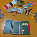 （左から）ハトメパンチ、カラーゴム6mm、リボン3mm、ハトメ、ハサミ、接着剤　　（手前）完成したオリジナル野帳