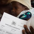 ウガンダのムラゴ病院で携帯届出システム (MobileVRS) により発行された出生証明書と子ども
