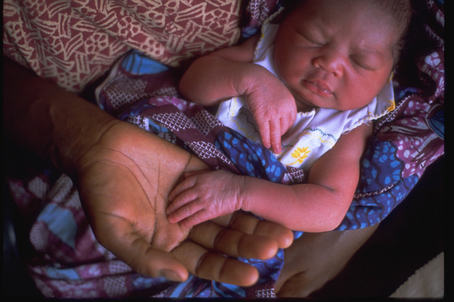 お母さんの腕の中で眠る生まれたばかりの赤ちゃん（ガーナ）