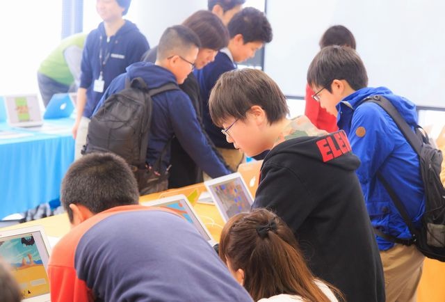 展示会場で他の生徒の作品を遊ぶ生徒