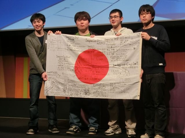 歴代のImagine Cup日本代表によるメッセージが寄せ書きされたフラッグを持つ、チーム「すくえあ」のメンバー