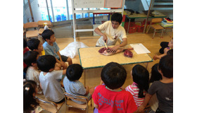 鹿の解体を見守る子どもたち