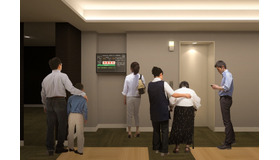 エレベーターホールに同システムの情報を表示するモニターを設置したイメージ。地震発生時に慌てて逃げることで二次災害に巻き込まれる可能性を軽減するシステムとなる（画像はプレスリリースより）