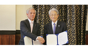 協定書署名の後、握手を交わす松本総長（右）と山口教育長（左）