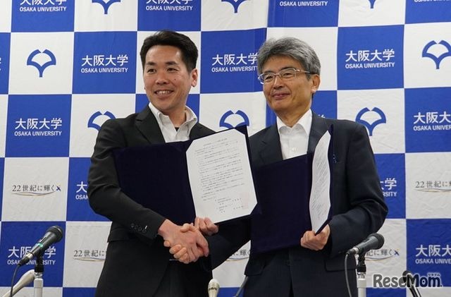 覚書を交換する大阪大学の平野俊夫総長（右）と箕面市の倉田哲郎市長