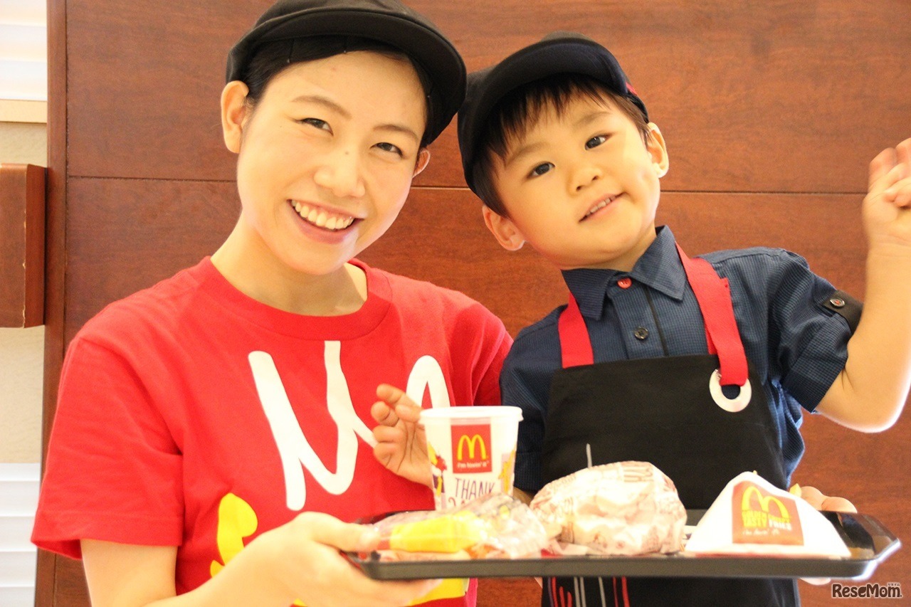 できたてのオリジナルバーガーを持って、クルーのお姉さんと一緒に記念撮影