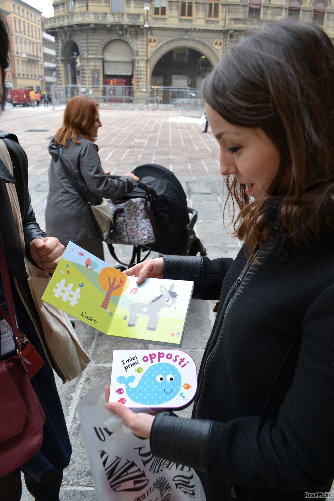 絵本専門店で絵本購入した母　奥はベビーカーを押す祖母