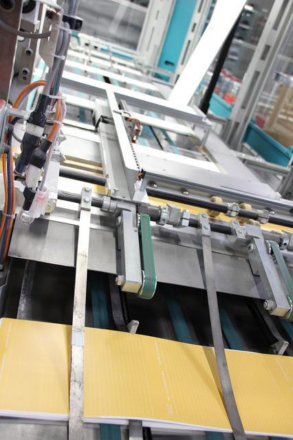 印刷が終わり、中紙となってでてきたものに表紙と裏紙がセットされます。目にもとまらぬ速さ、そして正確さ