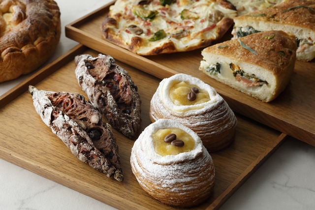 左)ショコラバゲット、左奥)タルトフランベ、右)キャフェ・バナーヌ、右奥)スモークサーモンとポテトのフォカッチャ／ペストリーショップ Sweets & Deli