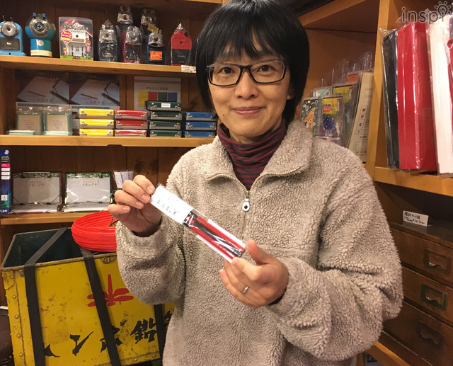 最初のオリジナル商品「半分鉛筆」を持つ櫻井さん。