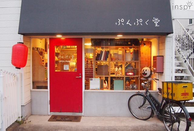 赤い扉が印象的なぷんぷく堂。トンボ鉛筆の自転車がトレードマーク。