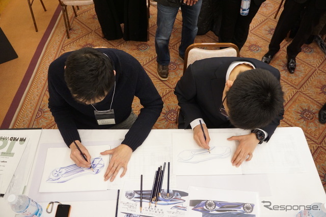 表彰式後には、プロの講師によるマンツーマンのスケッチ講習が行われる。従来は講師が受賞作品の意図を汲んでリファインした下絵をあらかじめ準備するのが通例だったが、今回の青木くんは3度目の受賞なので講習内容もグレードアップ。下絵にマーカーで塗り絵するのではなく、講師の指導を受けながら全体フォルムを線描き（ラインドローイング）する段階からスタートした。