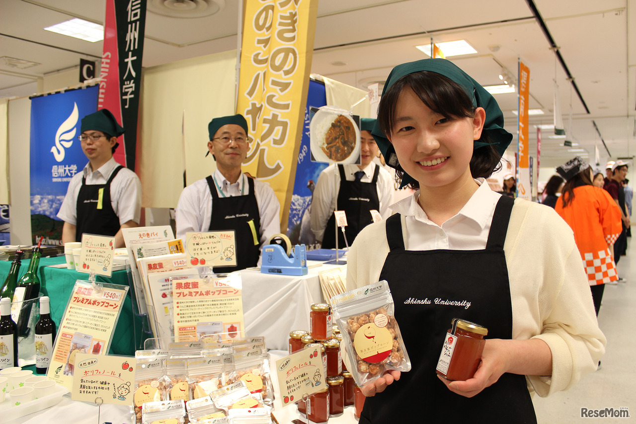 カリカリ、ふんわり甘く、りんごの皮から抽出した糖蜜液で仕上げた「果皮蜜プレミアムポップコーン」（1袋540円）は今までにない食べ心地。販売しているのは信州大学。教育学部4年生の湯本あゆみさんは、りんごの種類「紅玉」の皮を使った商品について丁寧、にこやかに教えてくれた