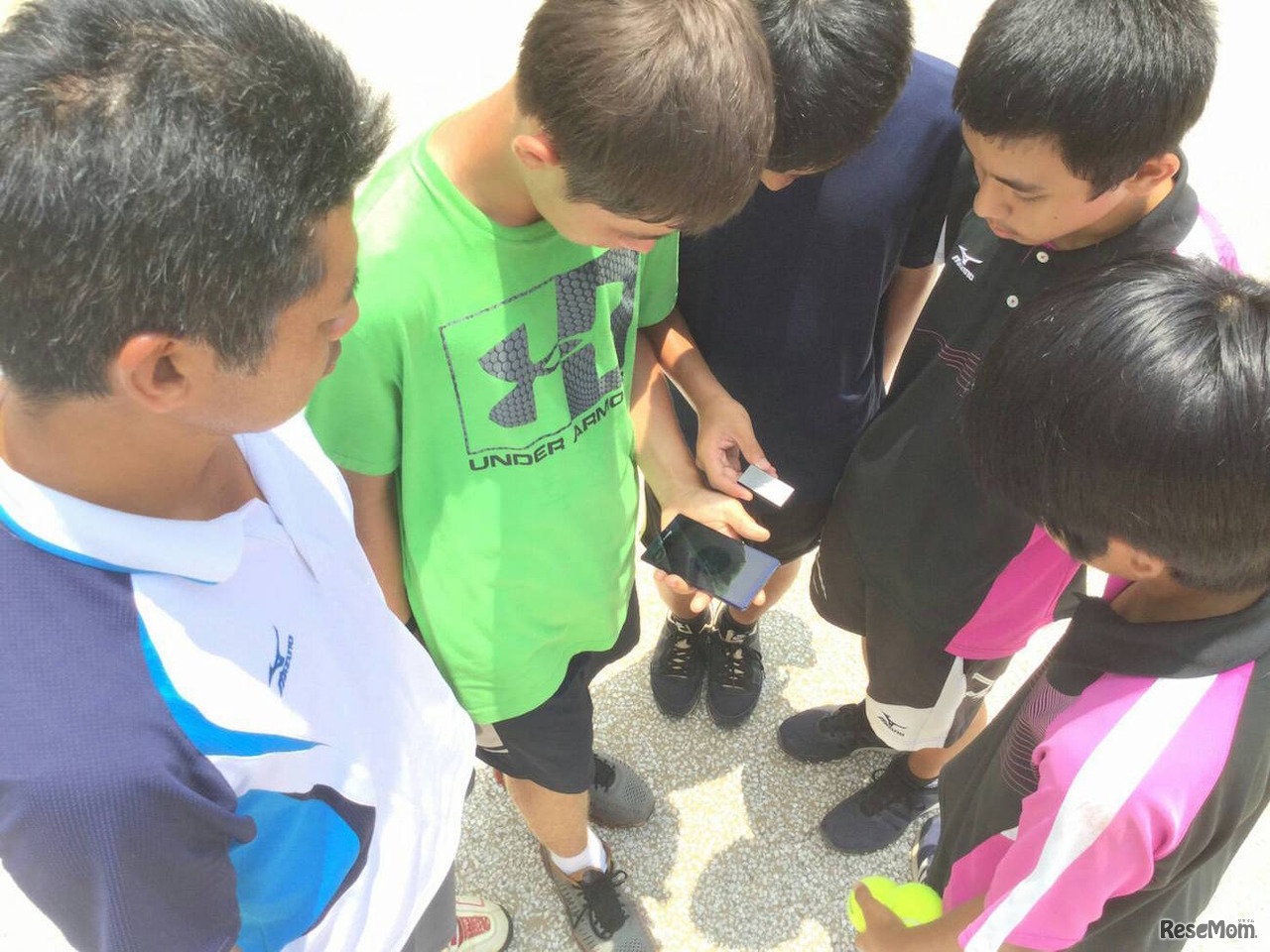 QSunデバイスを活用してコートのリアルタイム紫外線を確認する生徒たち