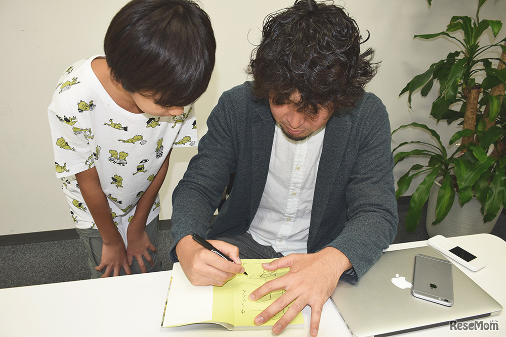 生き物大好き少年のバイブル「喰ったらヤバいいきもの」にサインをいただくようす