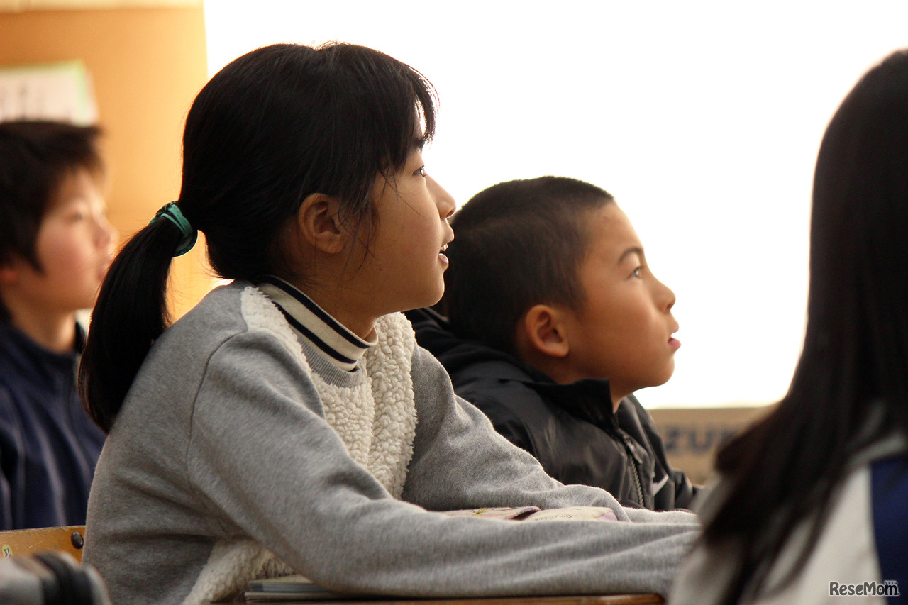 どうなるのかな？授業に真剣な児童たち。写真は電子黒板とタブレットを利用し進められる授業での一コマ