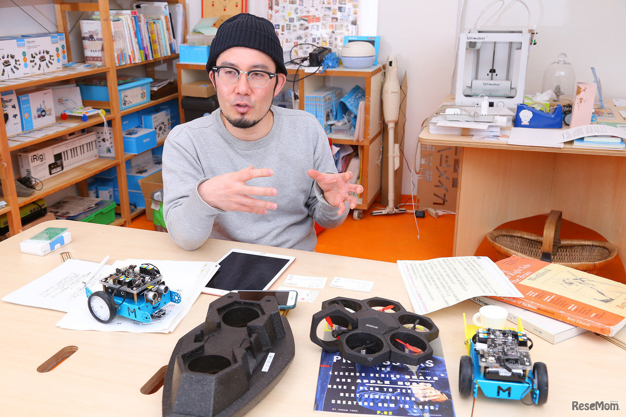 知育ドローン「Airblock」と同じMakeblockシリーズの「mBot」を並べ、子どもたちの「学びの未来予想図」を語るアザイ・コミュニケーションズ代表取締役 久木田寛直氏