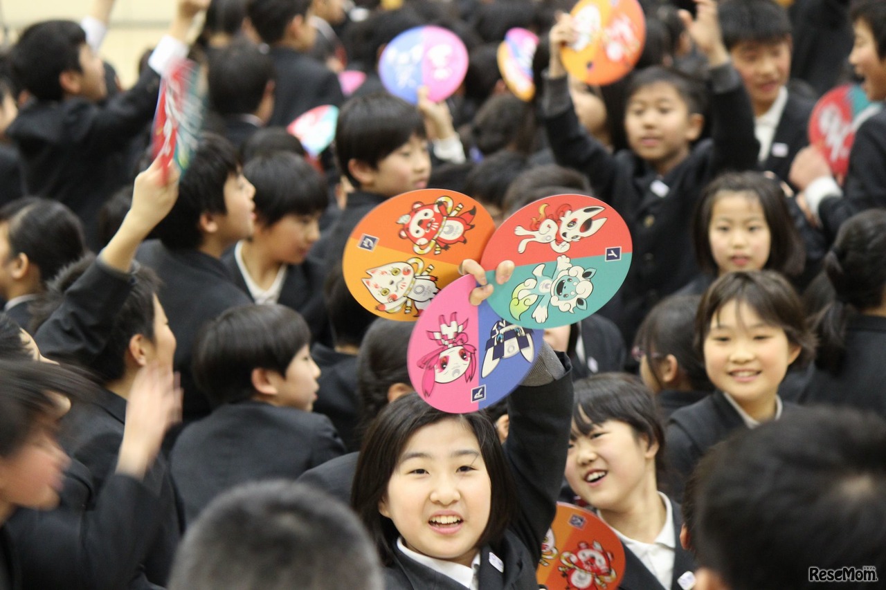 児童らには最終候補案の3作品がプリントされたうちわが配られた（最終的に、ア以外のうちわは回収された）