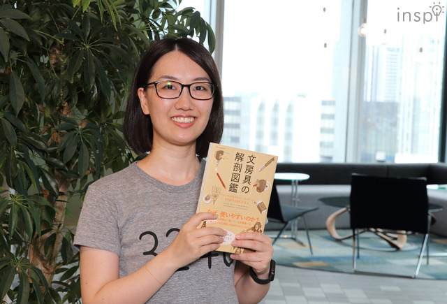 著書『文房具の解剖図鑑』を手にするヨシムラマリさん