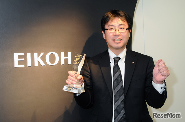 トロフィーを手に喜びの表情を見せる鈴木氏