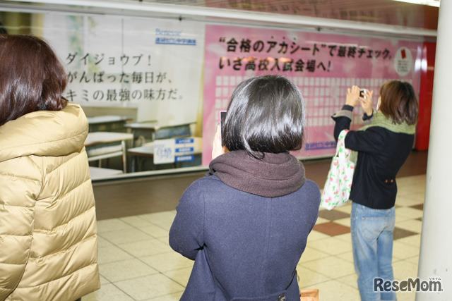 道行く人がポスターの櫻井君を撮影