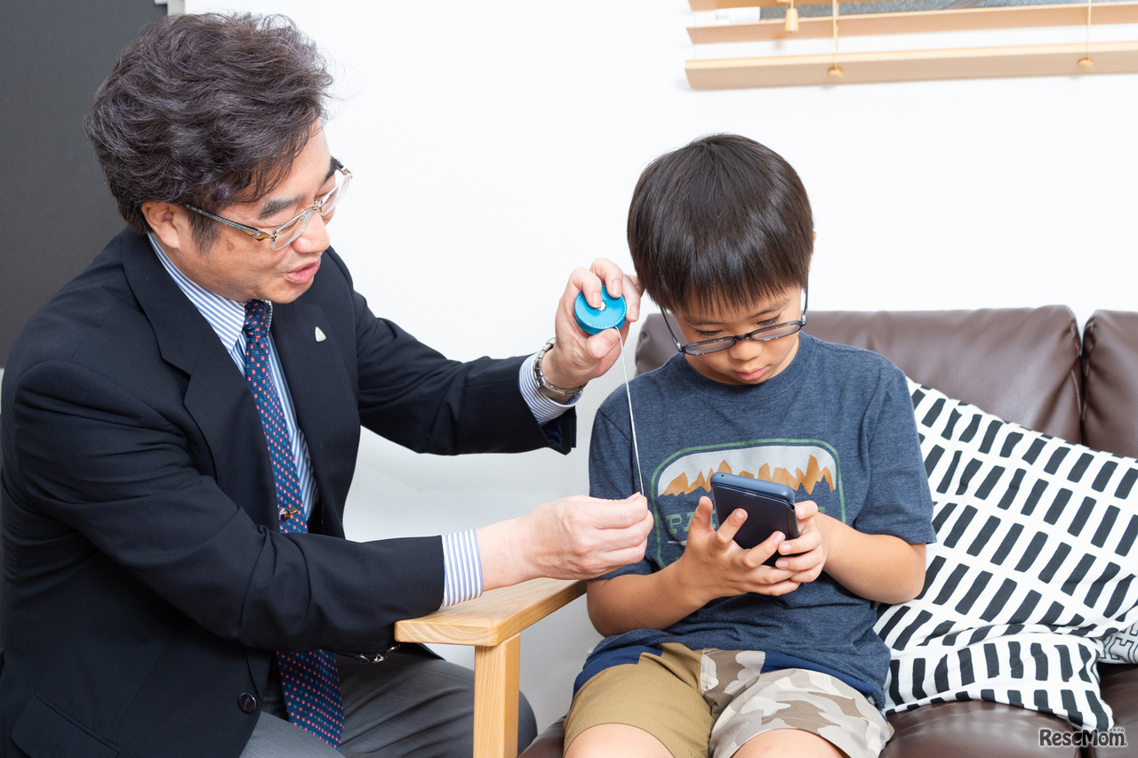 子どもたちに普段使っている姿勢になってもらい、画面と目との距離を測定。スマホは12センチほどしか離れていない…