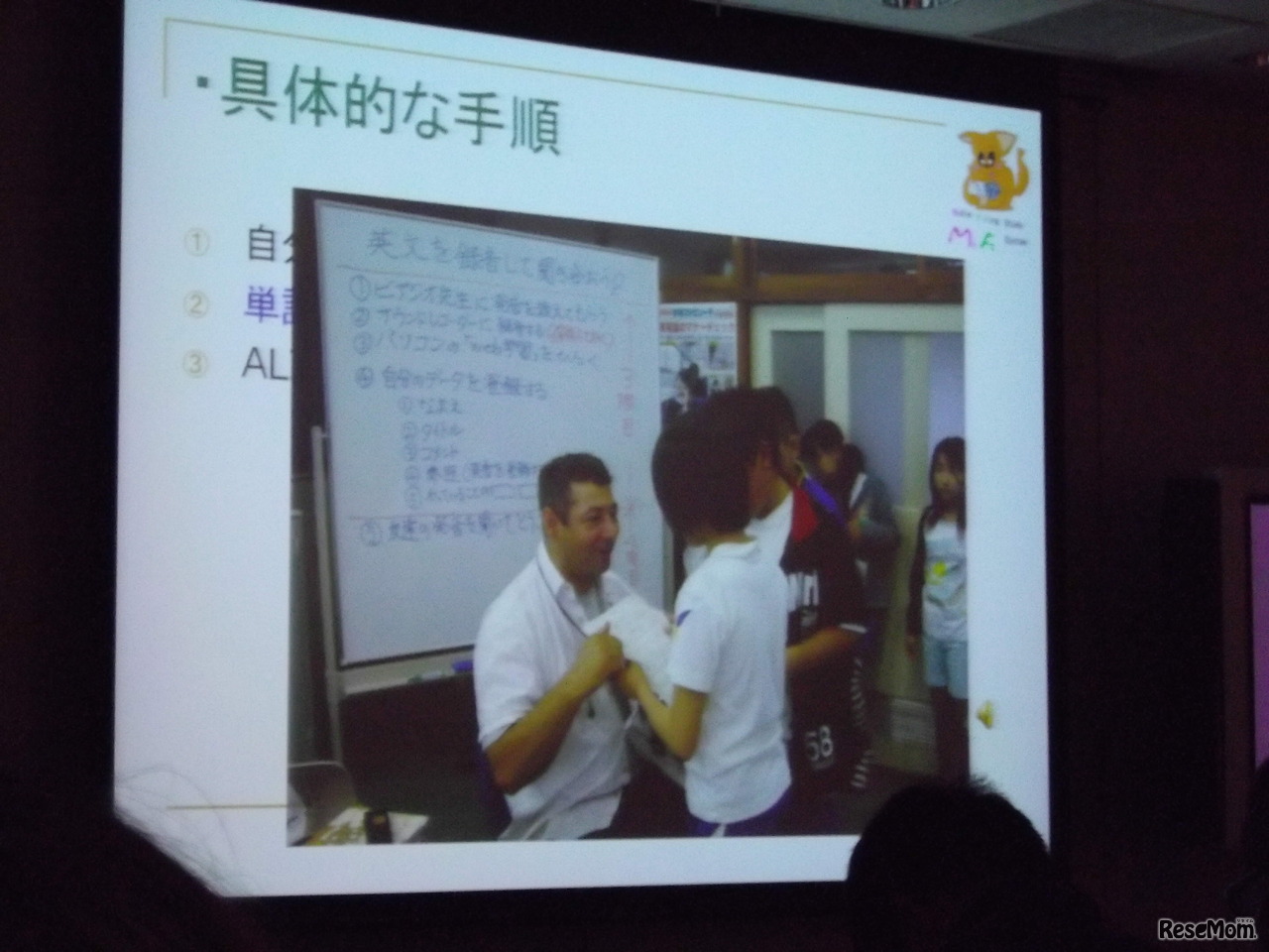 津市立新町小学校の学生がAETと正しい発音を練習している場面