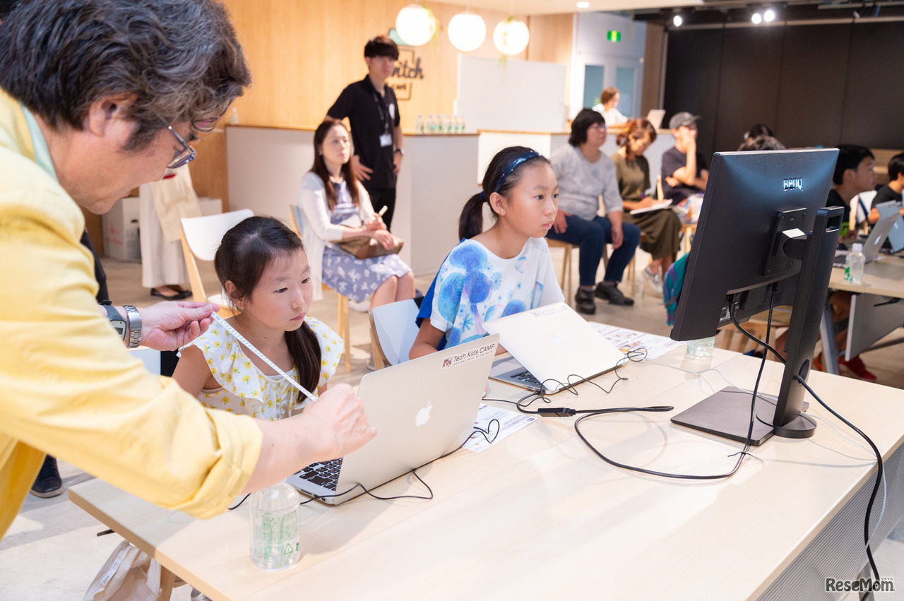 目と画面の距離を測る綾木先生。ノートパソコンでの作業の場合、その距離は25cmと若干近め