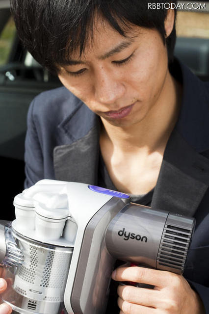 デザインと機能が一体化したDC31のデザインに見惚れる編集部N（※写真で使用しているハンディクリーナーはDC31 モーターヘッド シルバーとなります） デザインと機能が一体化したDC31のデザインに見惚れる編集部N（※写真で使用しているハンディクリーナーはDC31 モーターヘッド シルバーとなります）