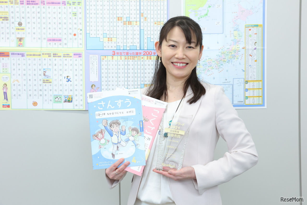 受賞のトロフィーとポピーワークを手にする塚本氏