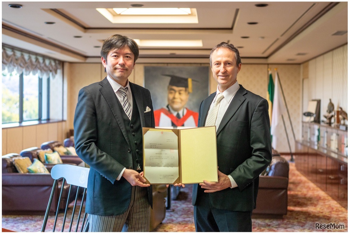 愛知県知事発行の認可書を手にする学園理事長（左）と学校長（右）