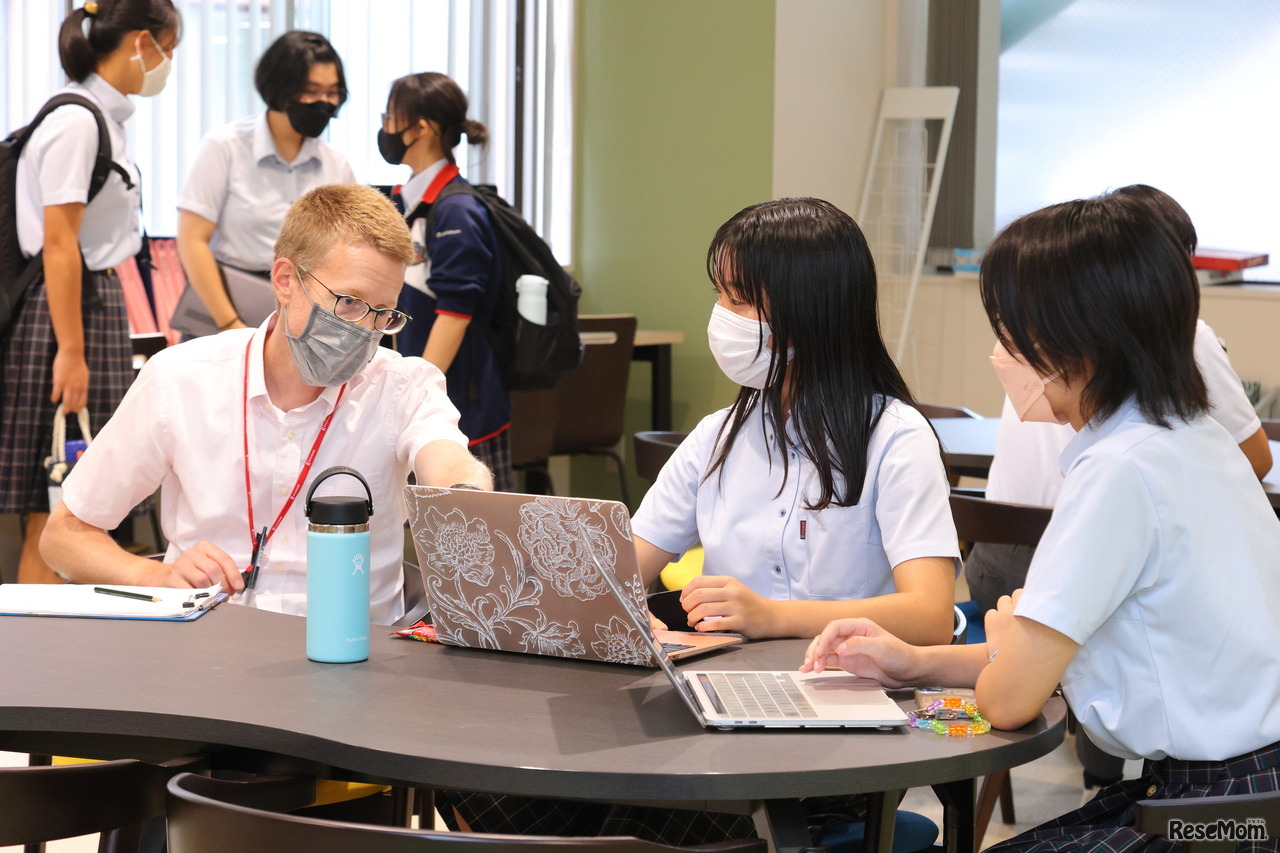 授業の合間に話し合う生徒とボーン先生のようす