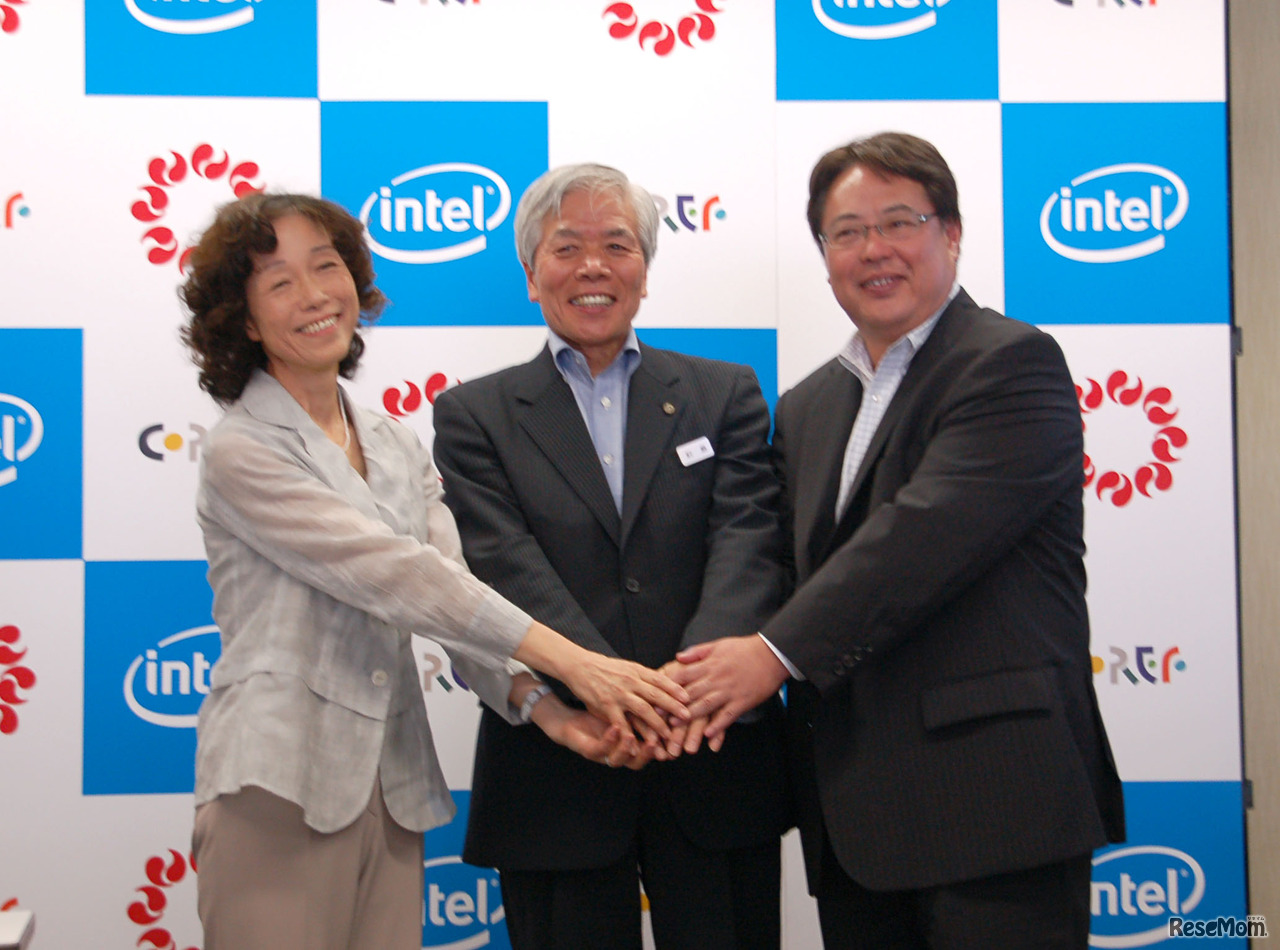 協定書にサインをし握手を交わす3人