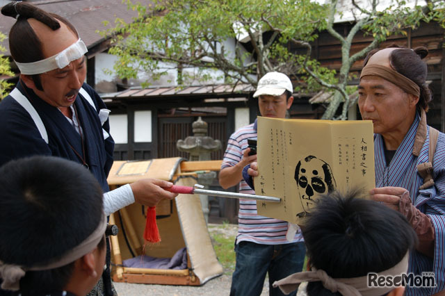「こいつが下手人だ」と頭が示すのは、当時の書き方をそのまま模した「手配書」