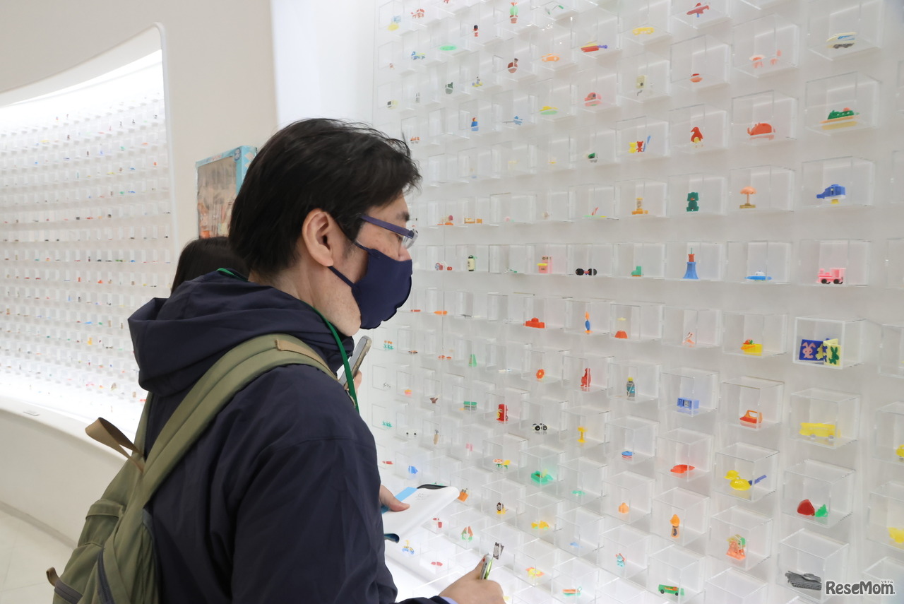 壁面いっぱいに飾られたおもちゃたち。多くの参加者が思い思いの「グリコのおまけ」を撮影する姿が見られた