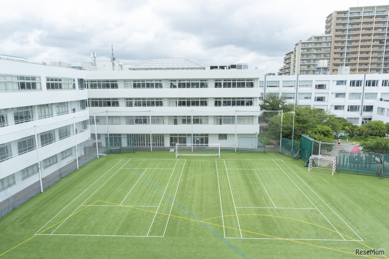 芝生のグラウンドを取り囲むように同じ敷地内に幼稚園、高校、中学校がある