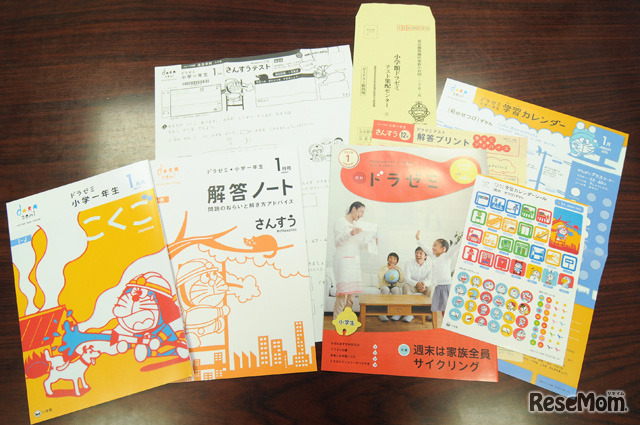 毎月送られてくる教材一式（小学一年生コースの場合）。テキスト（こくご・さんすう）、保護者向け情報誌「月刊ドラゼミ」、添削テスト、学習カレンダー＆シール