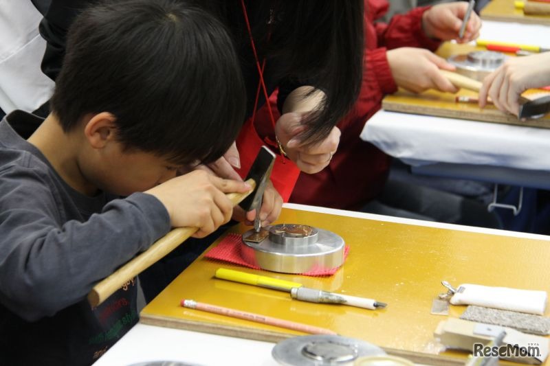 型で打ち抜いた金属に刻印など加工してオリジナルストラップをつくる