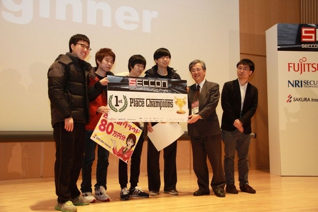優勝チーム「TOEFL Beginner」を祝福するSECCON実行委員の佐々木良一 東京電機大学 教授