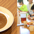 緑の学園に到着後、昼食のダムカレーをほおばる