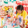 こども縁日・こども店長体験子どもたちが縁日の店長となって接客やサービス提供を行う、こども万博の象徴的なコンテンツです。射的、ヨーヨー釣り、千本くじなどの縁日を子どもたち自身が運営します。大人が用意した体験をするのではなく、子ども自身が主体的に行動し、困りごとを周りと協力して解決する力を養います。ストライプ柄の屋台やサーカスをイメージした装飾で、会場を明るい雰囲気に彩ります。