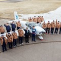 軽量飛行機を囲んで記念撮影するテクノアカデミーの学生と室屋義秀選手