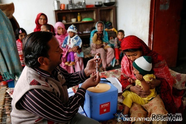 人里離れた村の子どもたちも予防接種を受けられるよう、保健員を派遣。はしかの予防接種を受けにきた親子たち。（パキスタン）