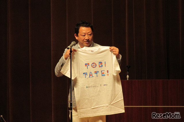 プロジェクトリーダー船橋力氏による「TOBITATE」Tシャツの紹介には会場からどよめきも　撮影：佐久間武