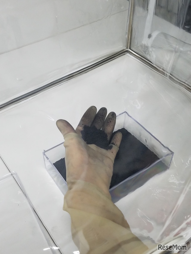 「はやぶさ2 TeNQ特別展示」グローブボックスを使用して模擬土壌を触る体験