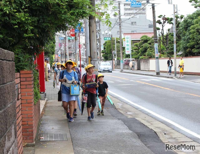 子どもたちが通る道では、黄色いシャツを着たスタッフが見守っている