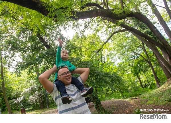 3歳の息子と外で遊ぶ父親。両親は、保護者向けの子育て支援プログラムを受けている（セルビア、2021年4月撮影） (c) UNICEF_UN0465937_Pancic